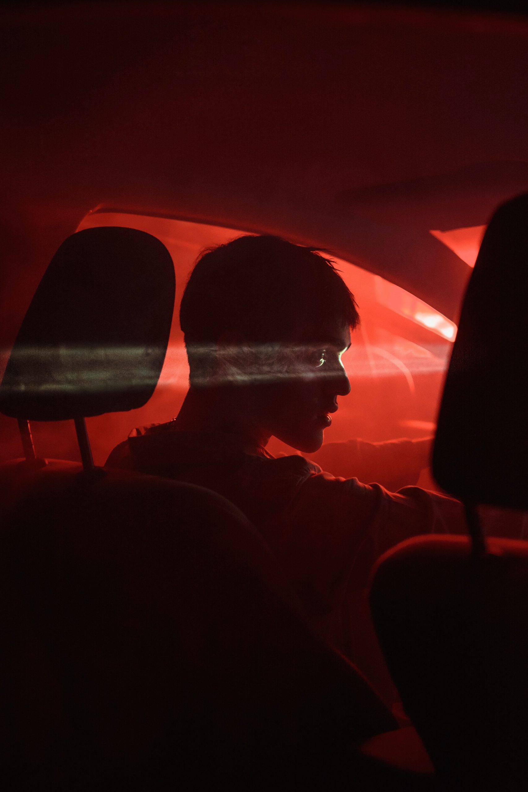 A young man in neon light demonstrating driving under drug influence