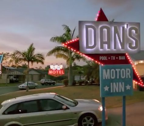A motel sign and a car driving through