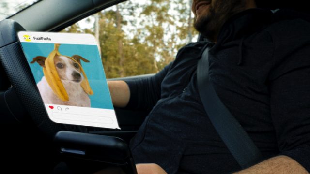 Man looks at social media feed while driving