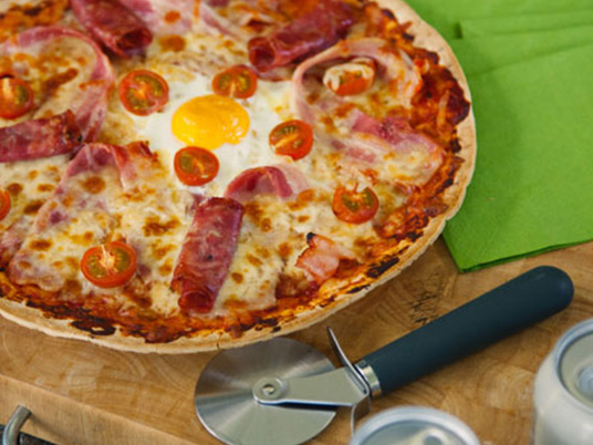 Breakfast pizza with tomatoes and fried egg