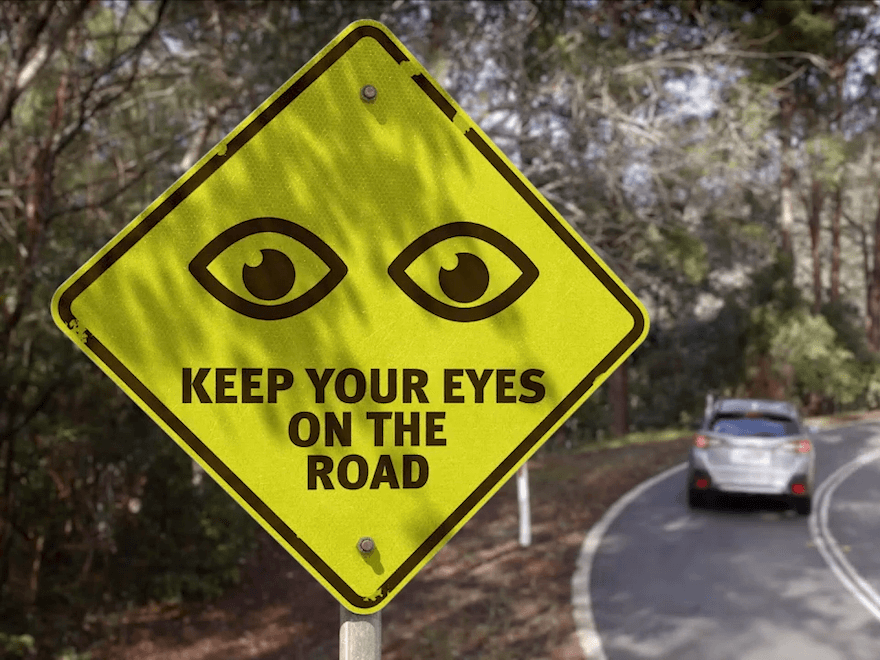 A yellow road sign that says 'Keep your eyes on the road'