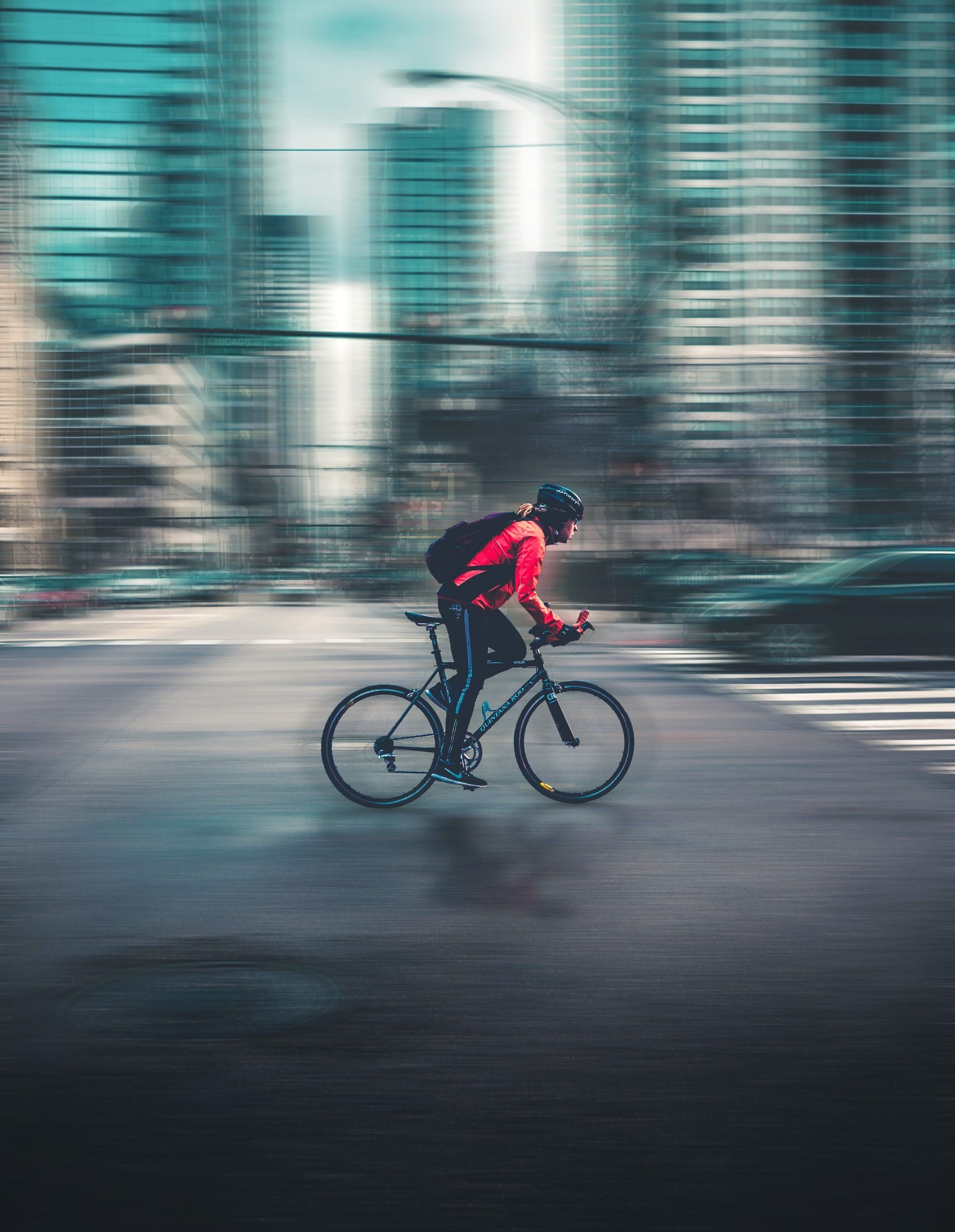 Bike rider in full gear rides on road in urban area