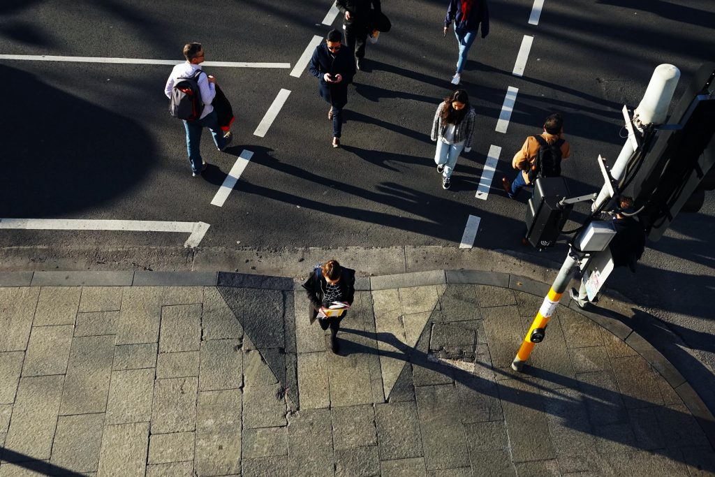 Pedestrians cross the road at the traffic lights in city area