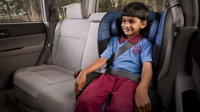 Young school child in a booster seat