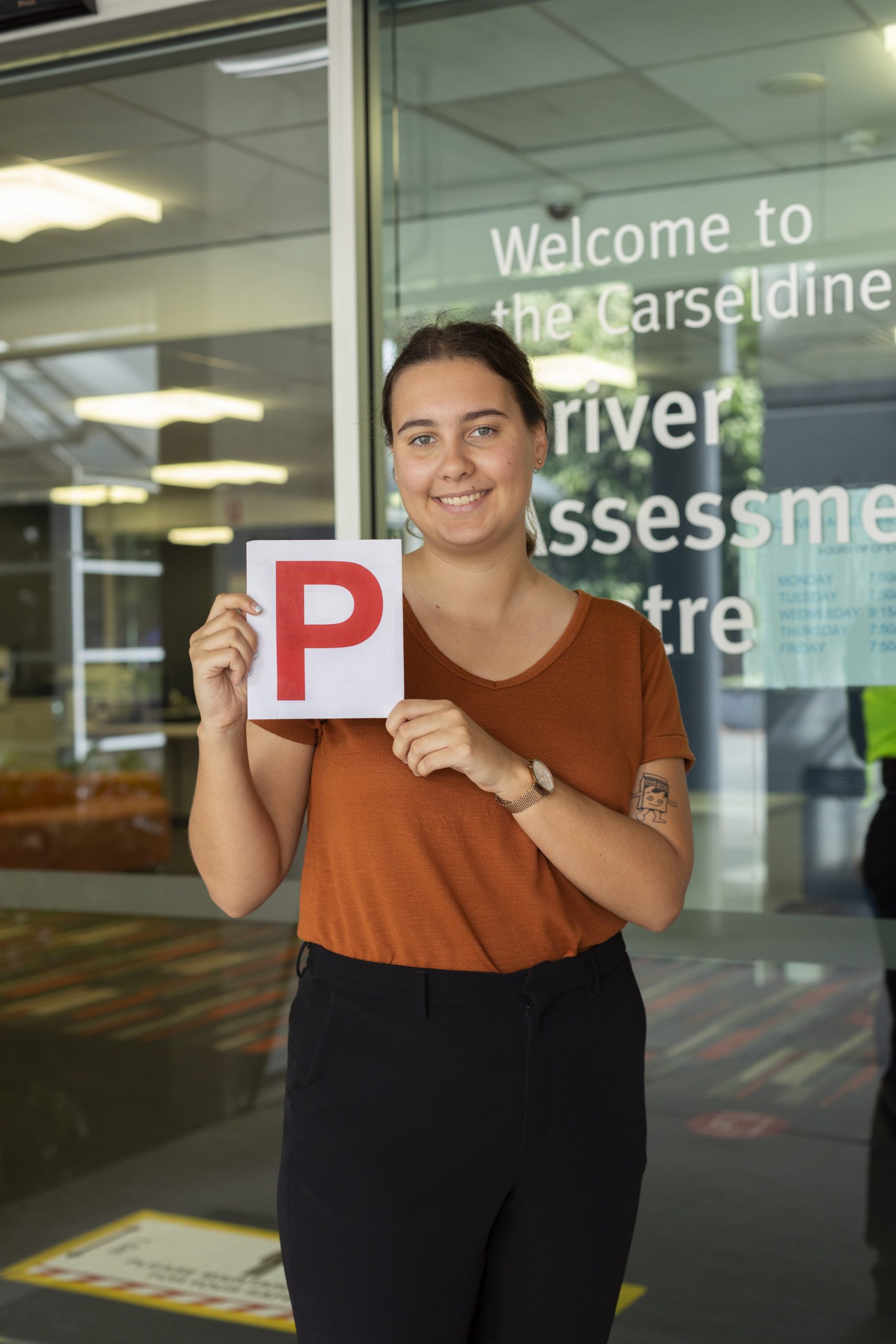 Young driver holding P plate at Carseldine Driver Assessment Centre