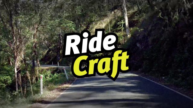 A road surrounded by trees with the Ride Craft logo in the middle