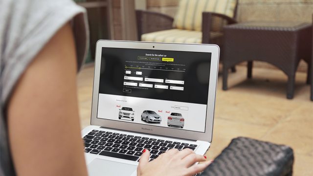 Person on laptop looking at car safety ratings on SafeCars app