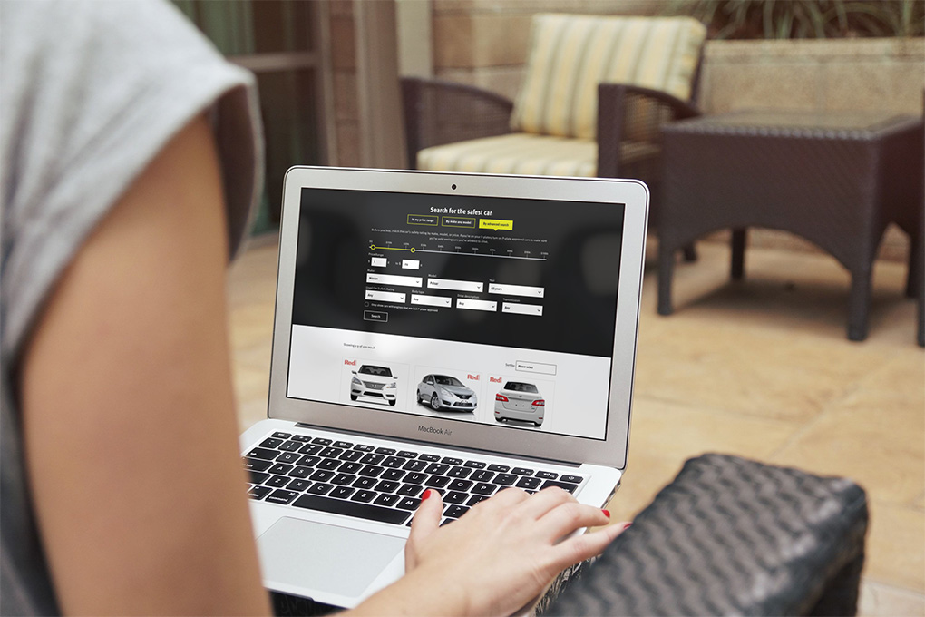Person on laptop looking at car safety ratings on SafeCars app