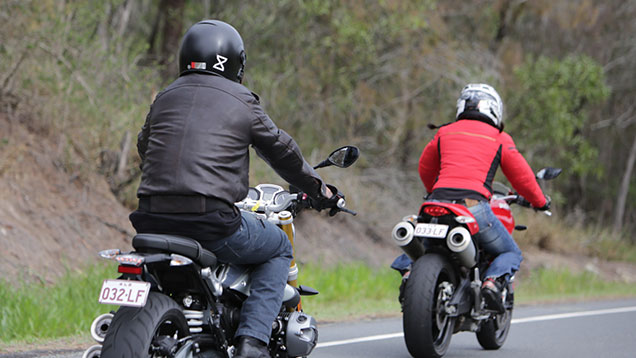 Two motorbike riders riding on a curvy road