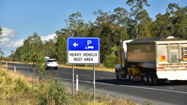 Road sign that says heavy vehicle rest area and indicates it is ahead.