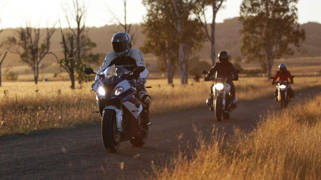 Three motorcycle riders going through a rural road